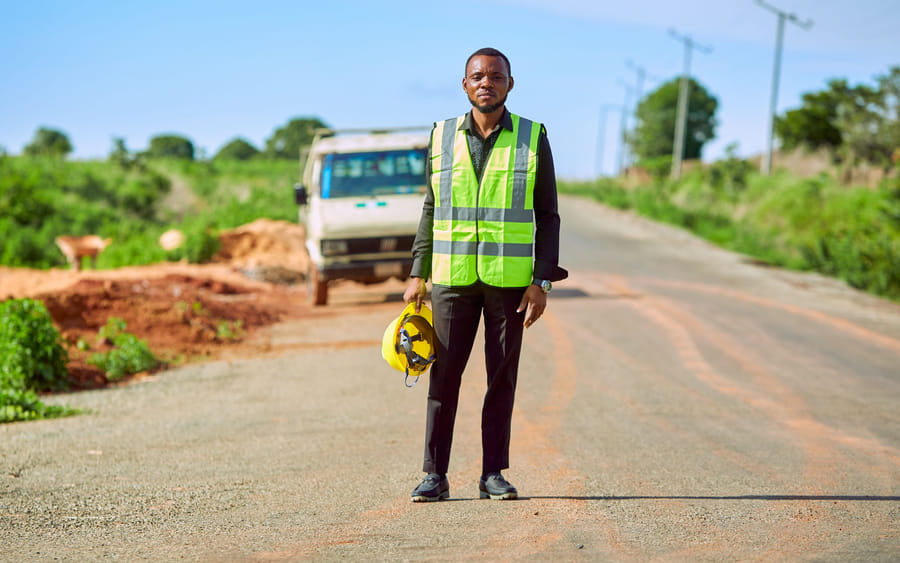 An engineer in high-visibility clothing on a road under construction