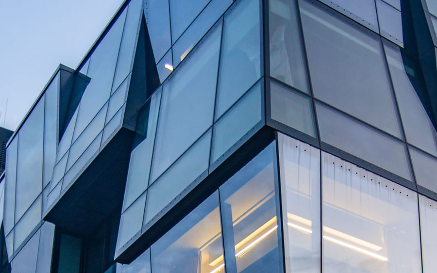 The faceted glass façade of a modern corporate office tower