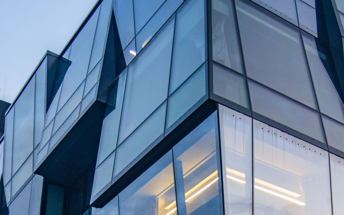 The faceted glass façade of a modern corporate office tower