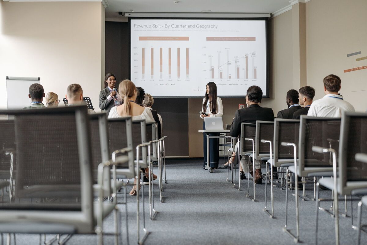 A quarterly performance review presented on screen to a seated team